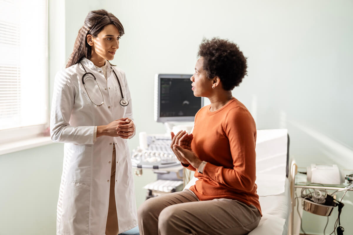 Doctor consulting with patient in examination room.
